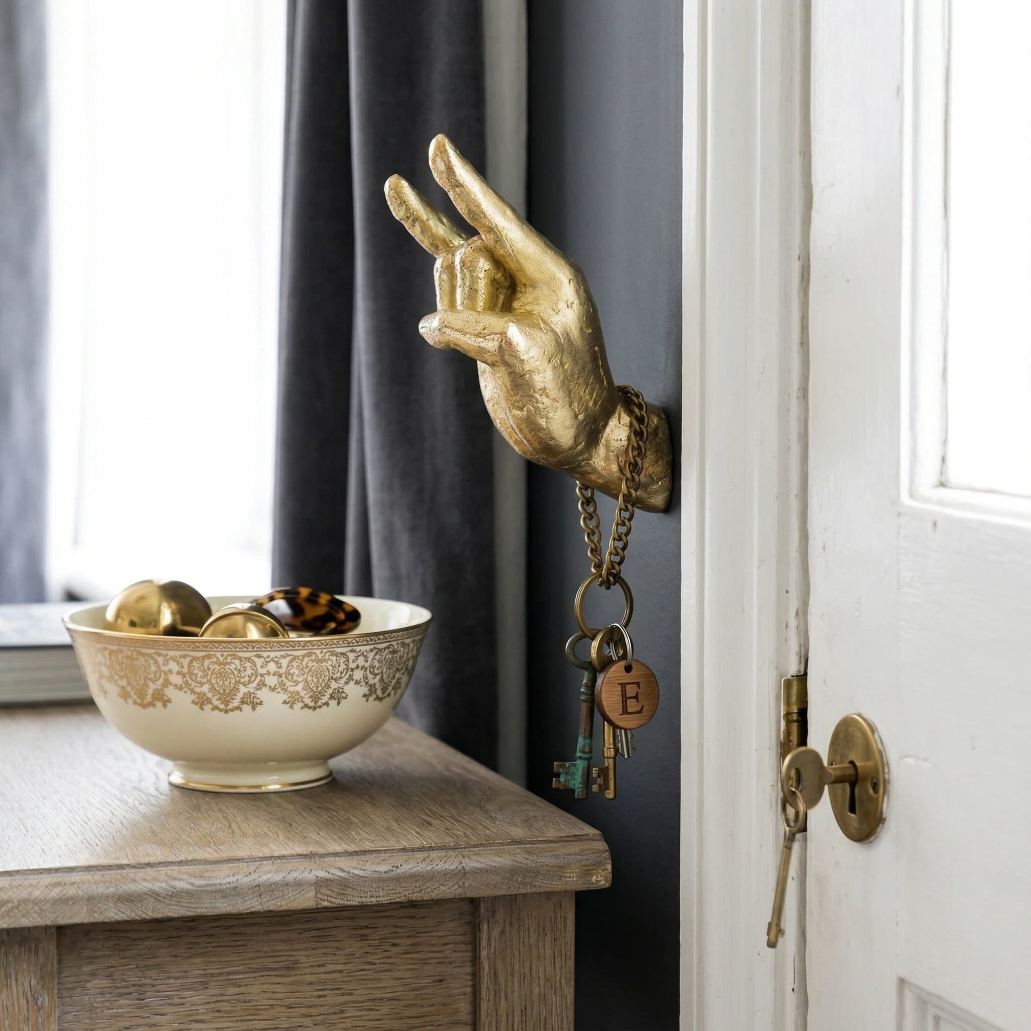 Gold hand wall hook holding keys