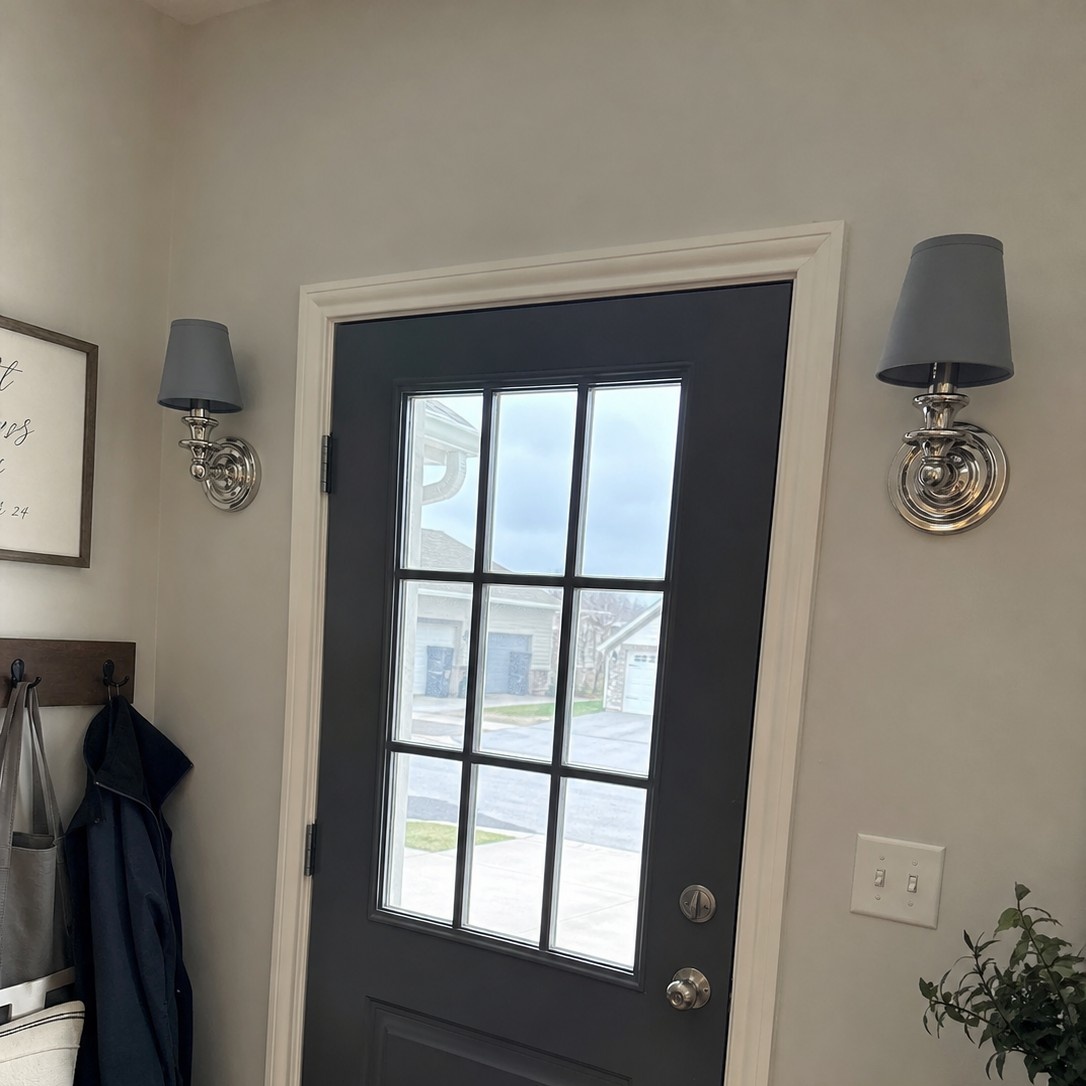 Customer review photo with wall sconces near entry door