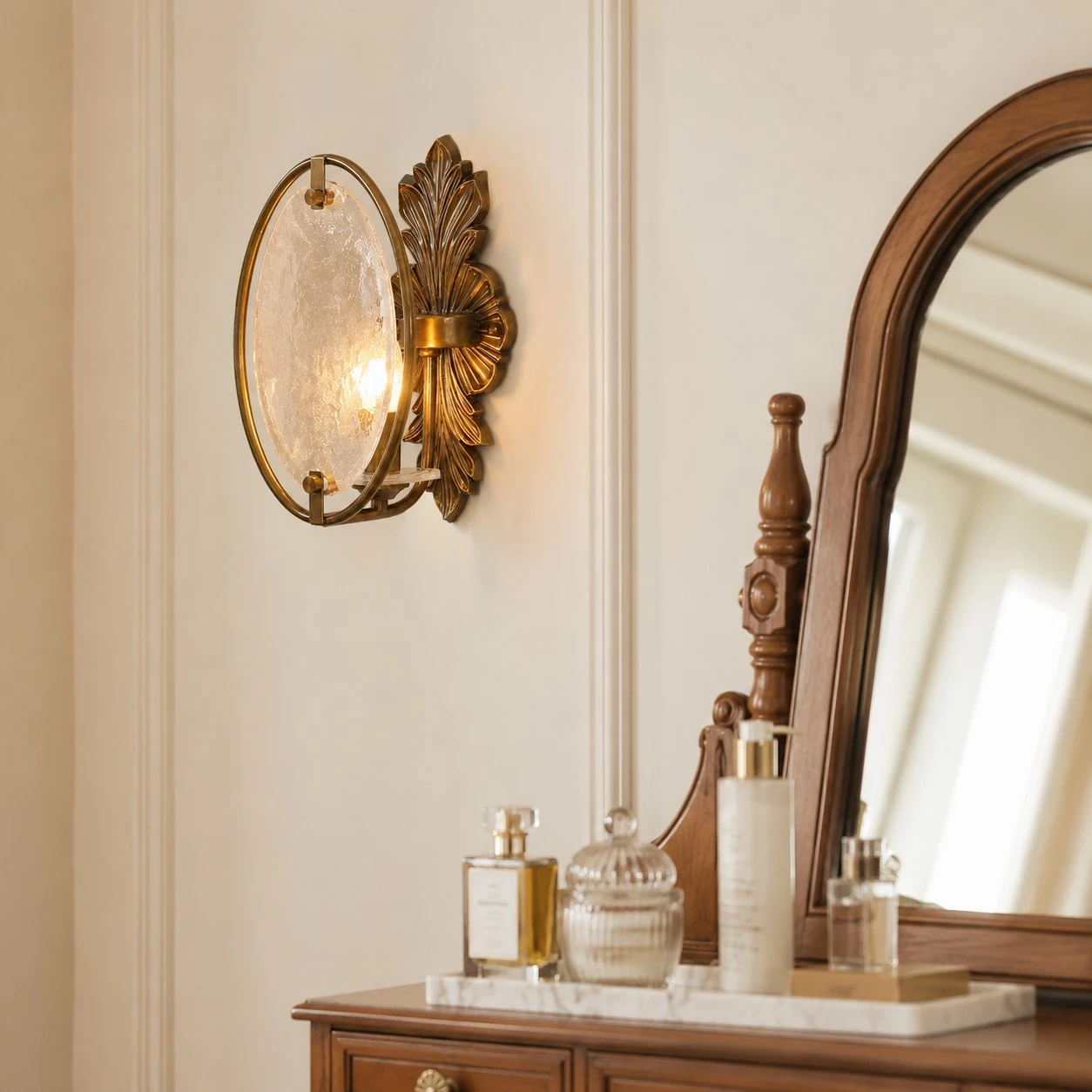 Antique brass textured glass wall sconce installed beside a vanity mirror